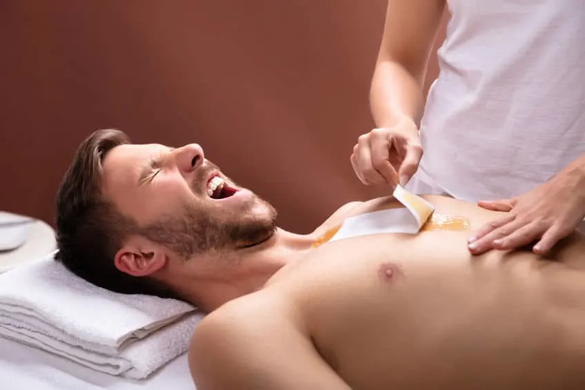 a picture of a man getting his chest waxed professionally