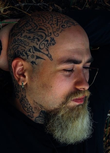 tattooed bald guy with long goatee 