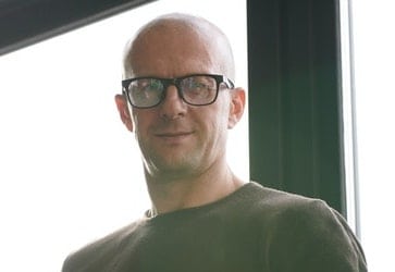 Man with shaved head and a pair of glasses