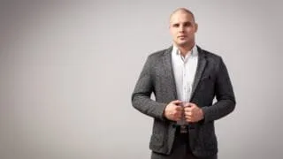 bald man in a grey suit with no tie and no beard ( )