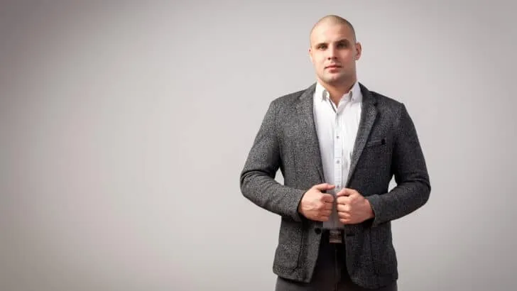 bald man in a grey suit with no tie and no beard ( )