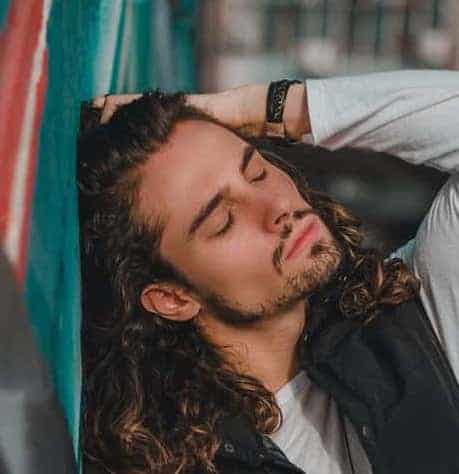 long curly hair with a goatee and chinstrap