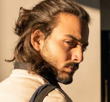 messy half man bun partnered with a goatee 