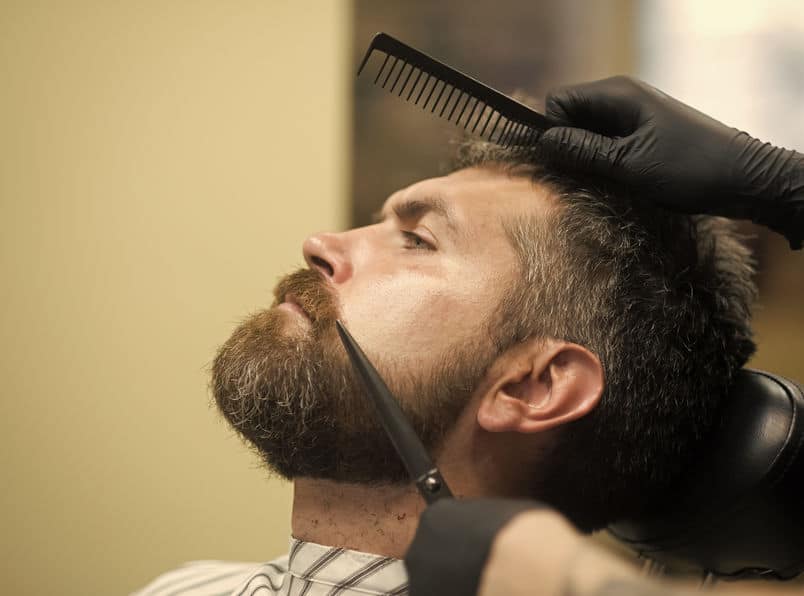 trimming mustache with a scissor