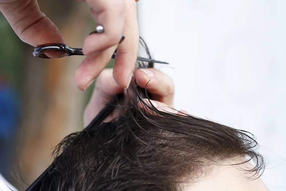 mans hair being cut by a barber