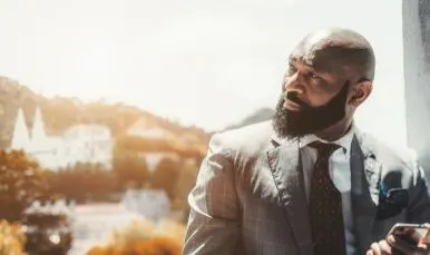 bald man in grey windowpane suit 