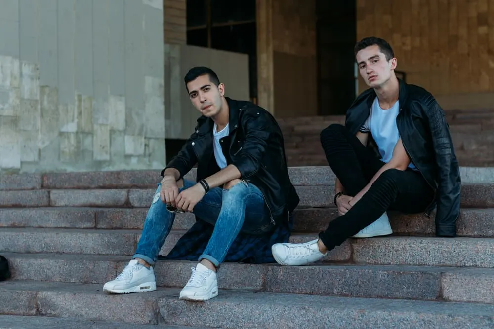 two men in white sneakers and jeans