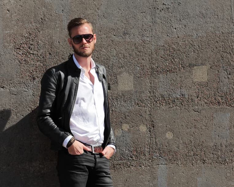 man with brown belt and black jeans 