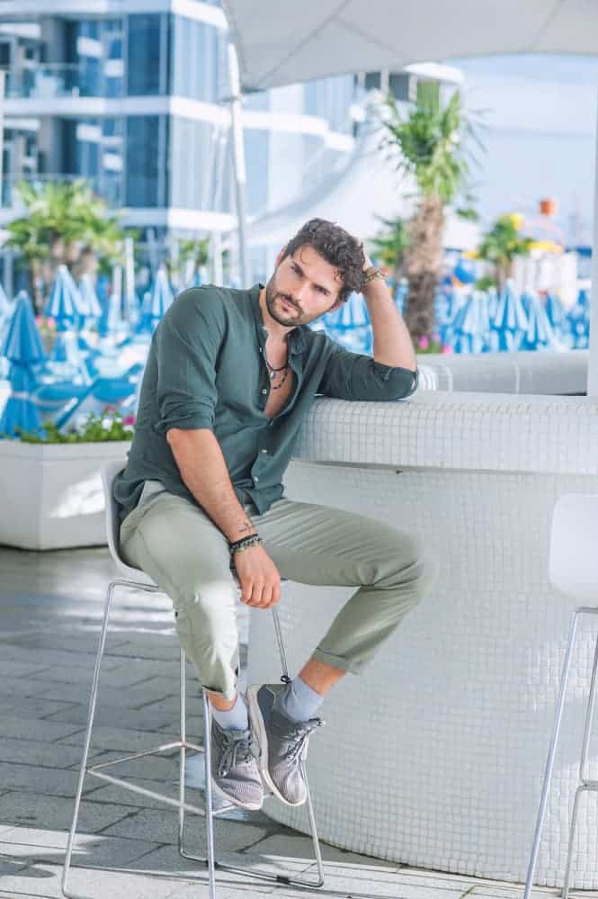 Fashion portrait of young man in green shirt and red pants poses over dark  blue wall with contrast light Stock Photo  Adobe Stock