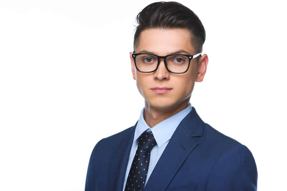 man in blue suit blue shirt and glasses