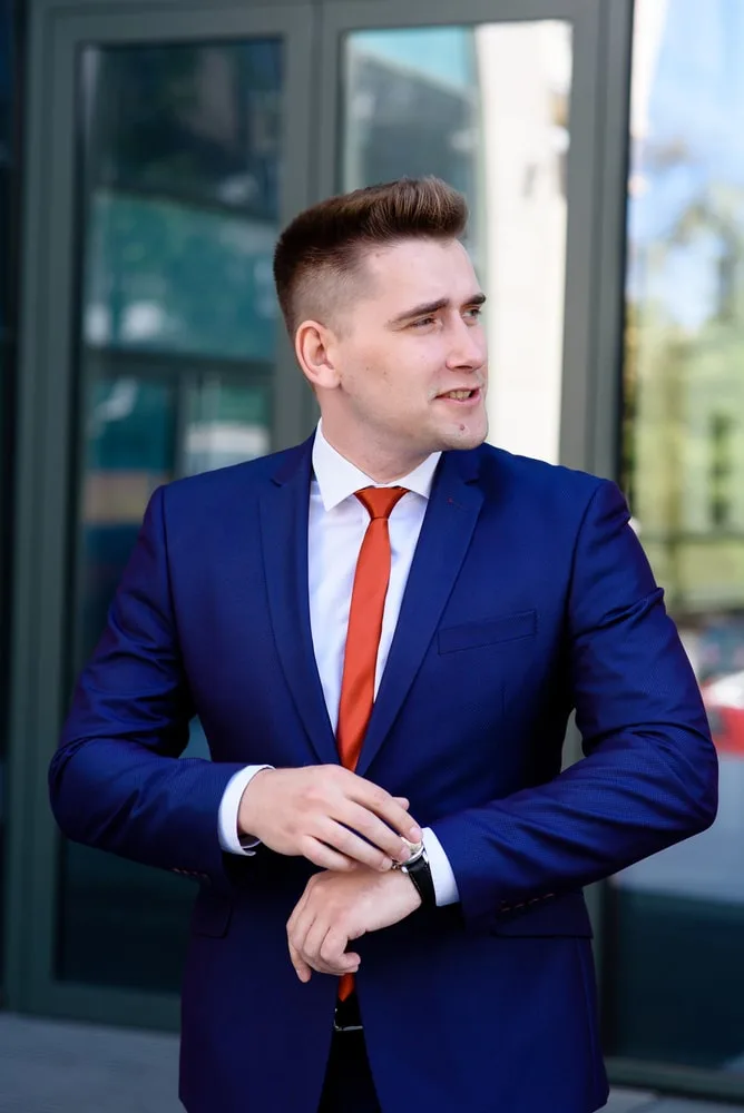 navy suit with light red tie