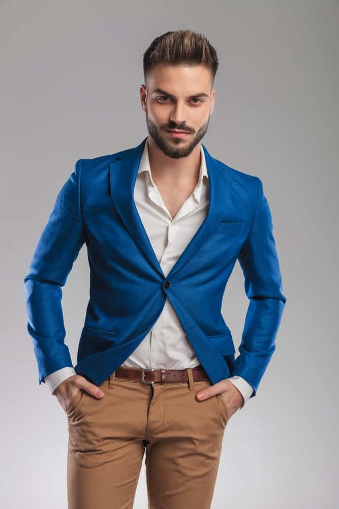 a young man wearing brown pants and a white shirt Stock Photo by Icons8