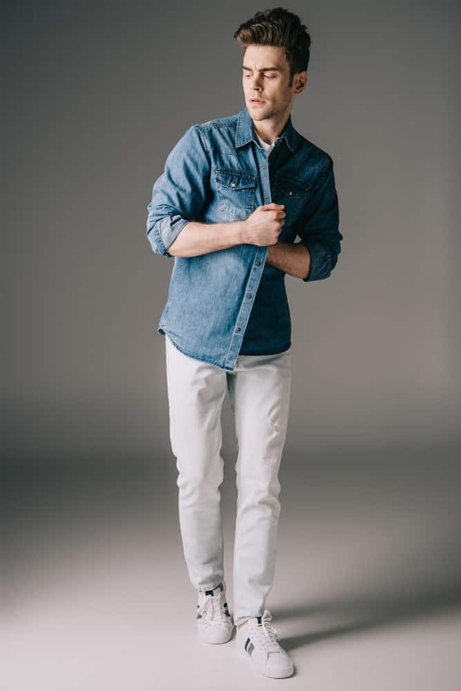 man in denim shirt and white jeans