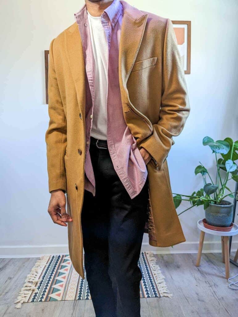 unbuttoned pink shirt black jeans camel coat