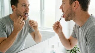 Man using tongue scraper for fresh breath